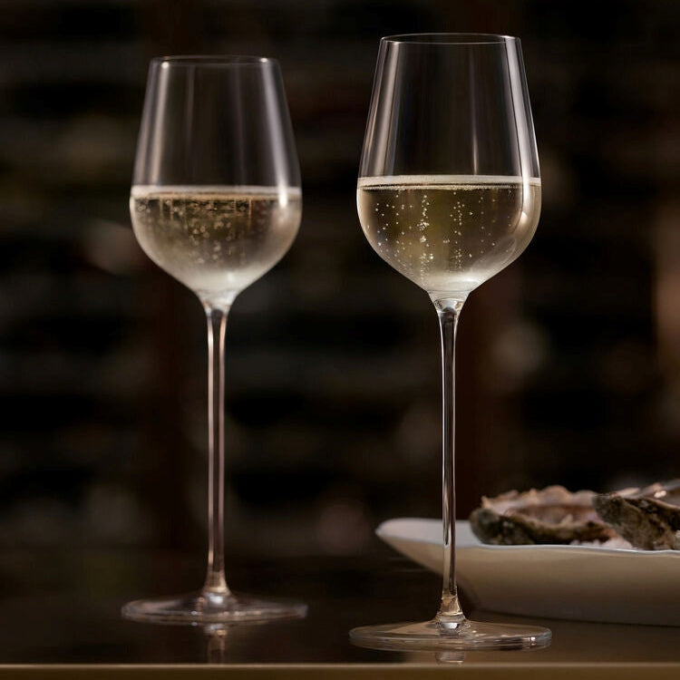 Two Champagne glasses with a drink on a table with a blurred background