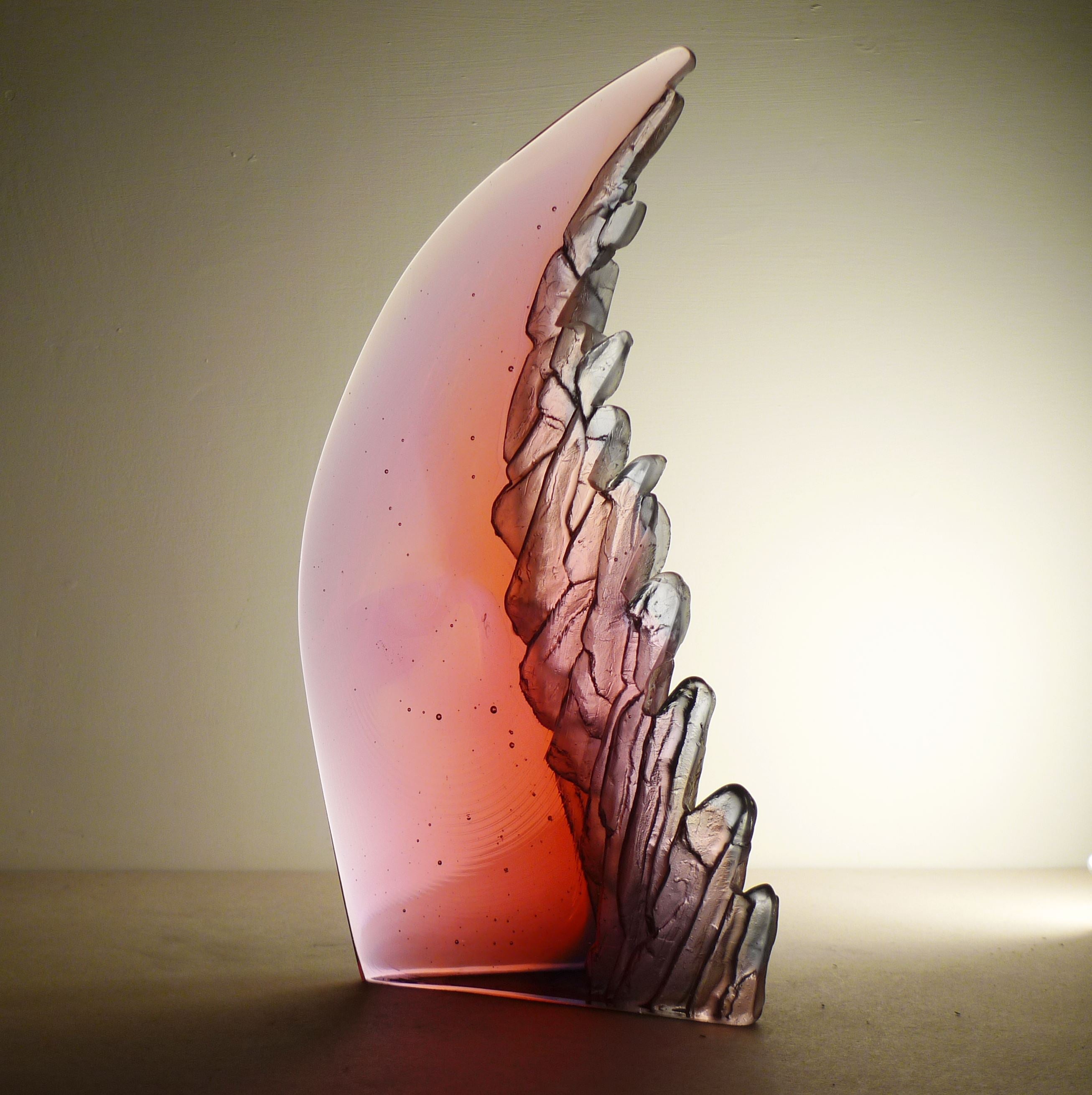 Glass sculpture with a pink and purple gradient on a beige background