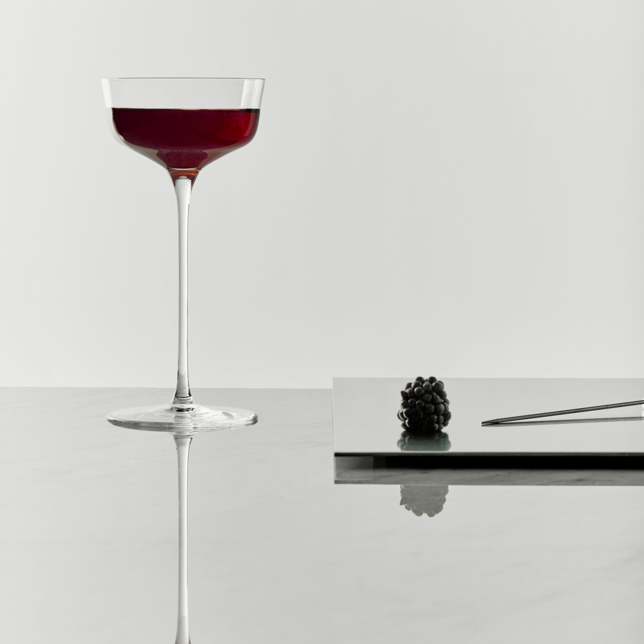 Orrefors Frantzen Cocktail glass with red liquid on a white background