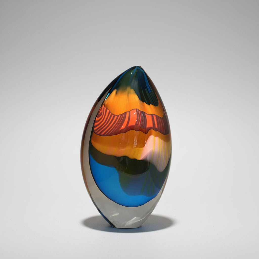 Colorful glass vase with a gradient from blue to orange on a white background