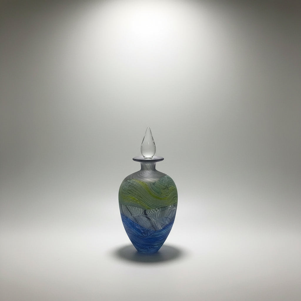 Thomas Petit Glass perfume bottle with a unique design on a white platform with neutral background