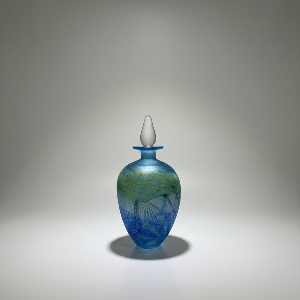 Blue glass vase with white stopper on a white platform in a neutral setting
