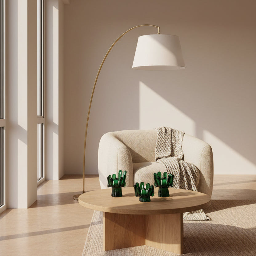 Kosta Boda Sunflower green glass candle holders shaped like hands on a marble surface.