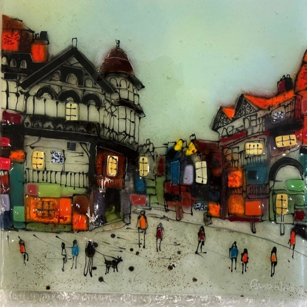 Colorful glass mosaic of a street scene with buildings and people.