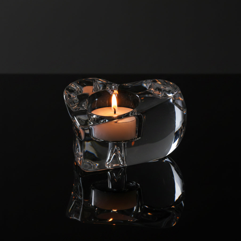 Kosta Boda Valentino Clear glass heart-shaped candle holder with a lit candle on a white background