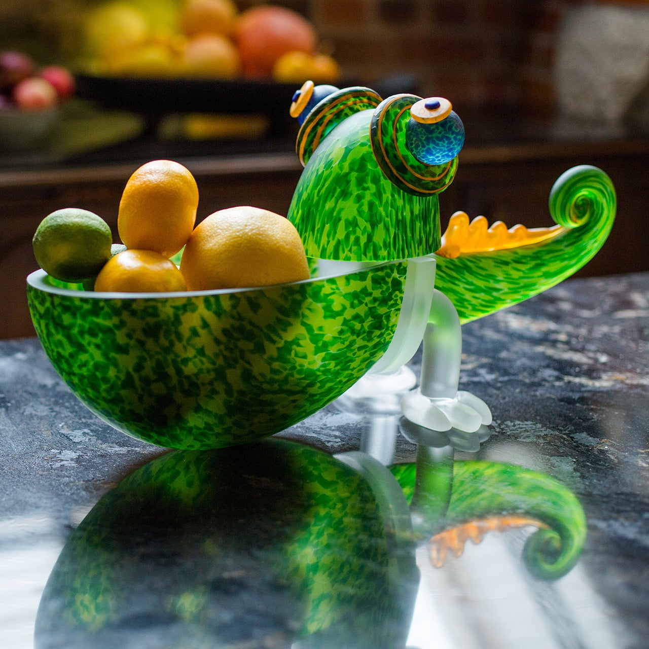 Decorative fruit bowl shaped like a green lizard on a kitchen counter.