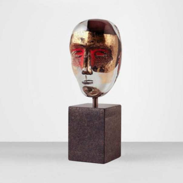 Abstract sculpture of a head on a metallic stand against a white background