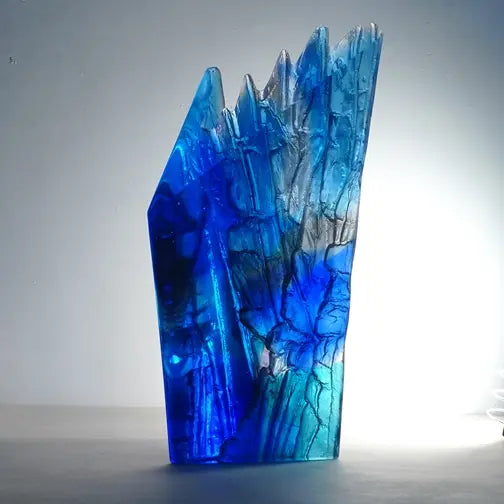 Blue glass vase with textured surface on a gray background