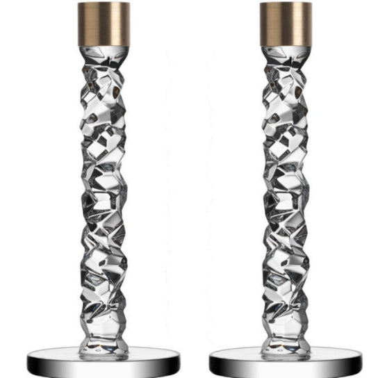 Two crystal candle holders with gold tops on a white background