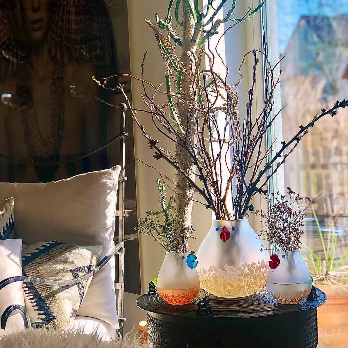 Borowski Glass vases with plants on a table by a window