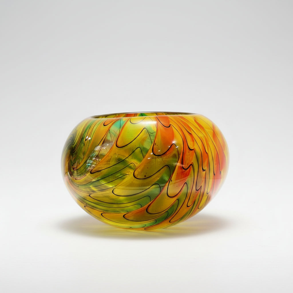 Colorful glass bowl on a white surface with a neutral background