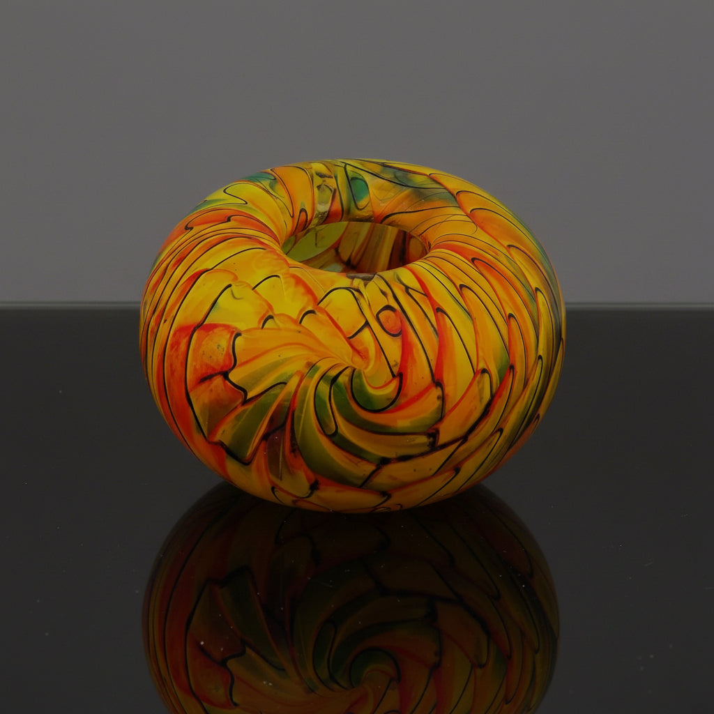 Colorful glass bowl with swirling pattern on a white background