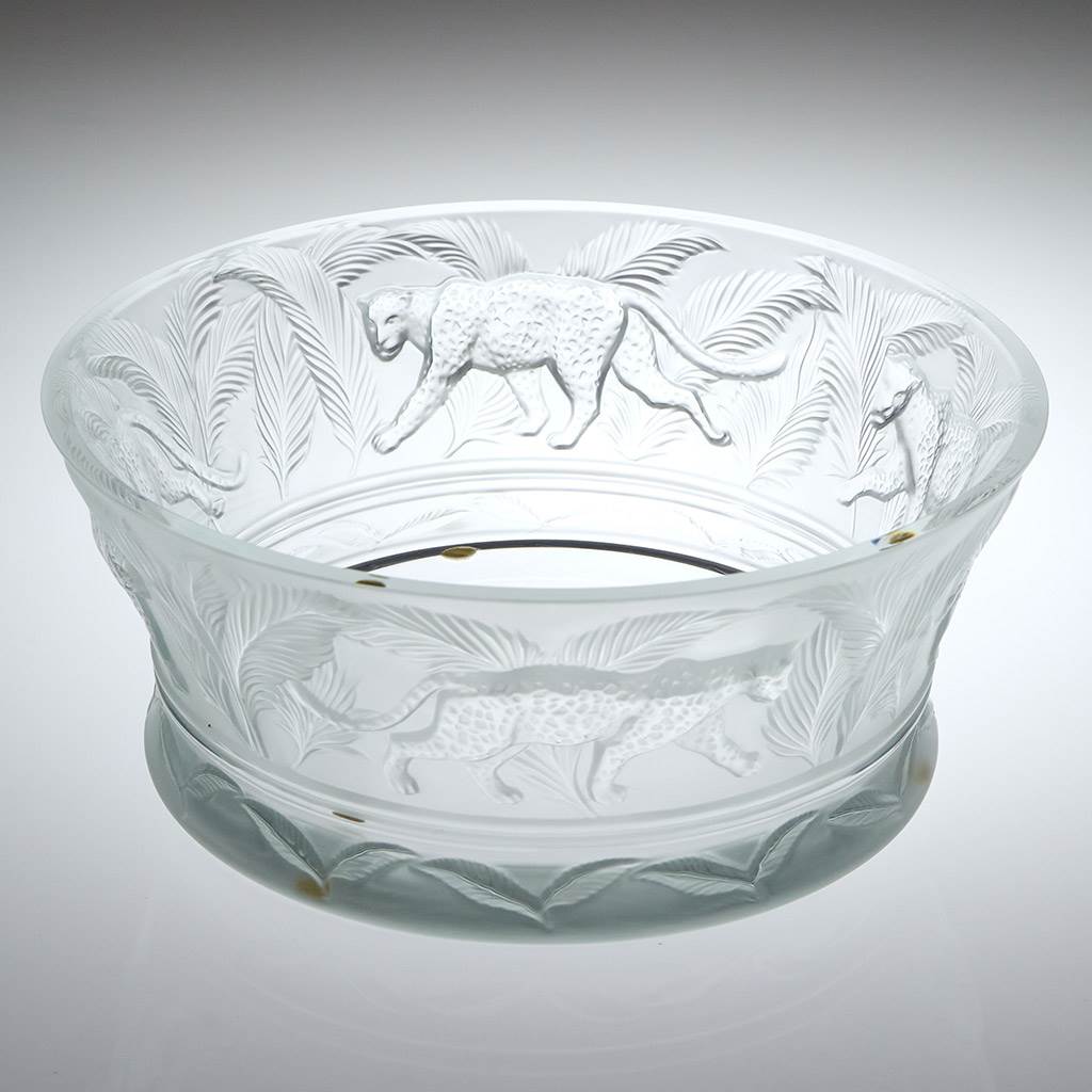 Clear glass bowl with engraved animal designs on a gray background