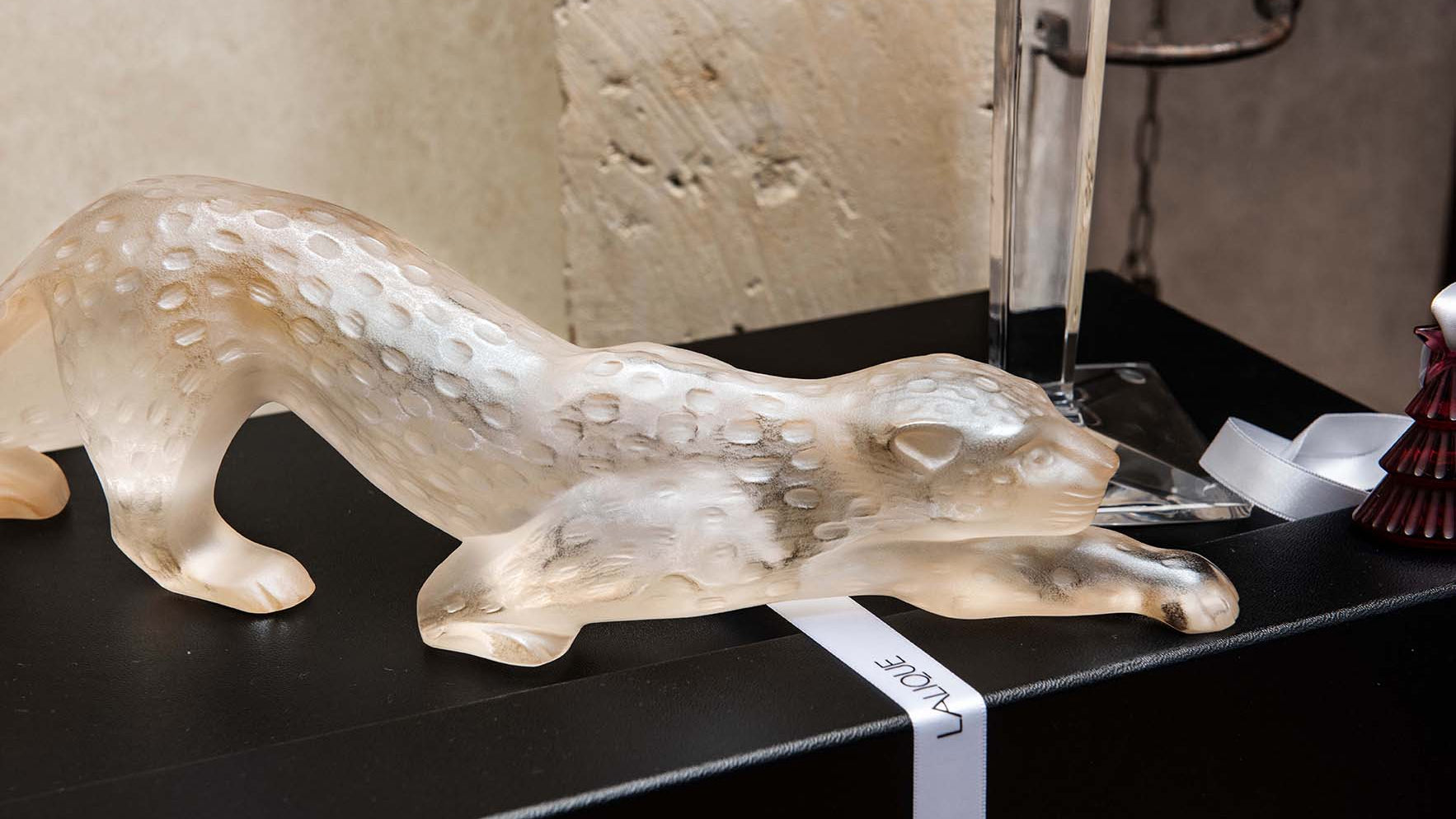Glass animal sculpture on a black surface with a price tag