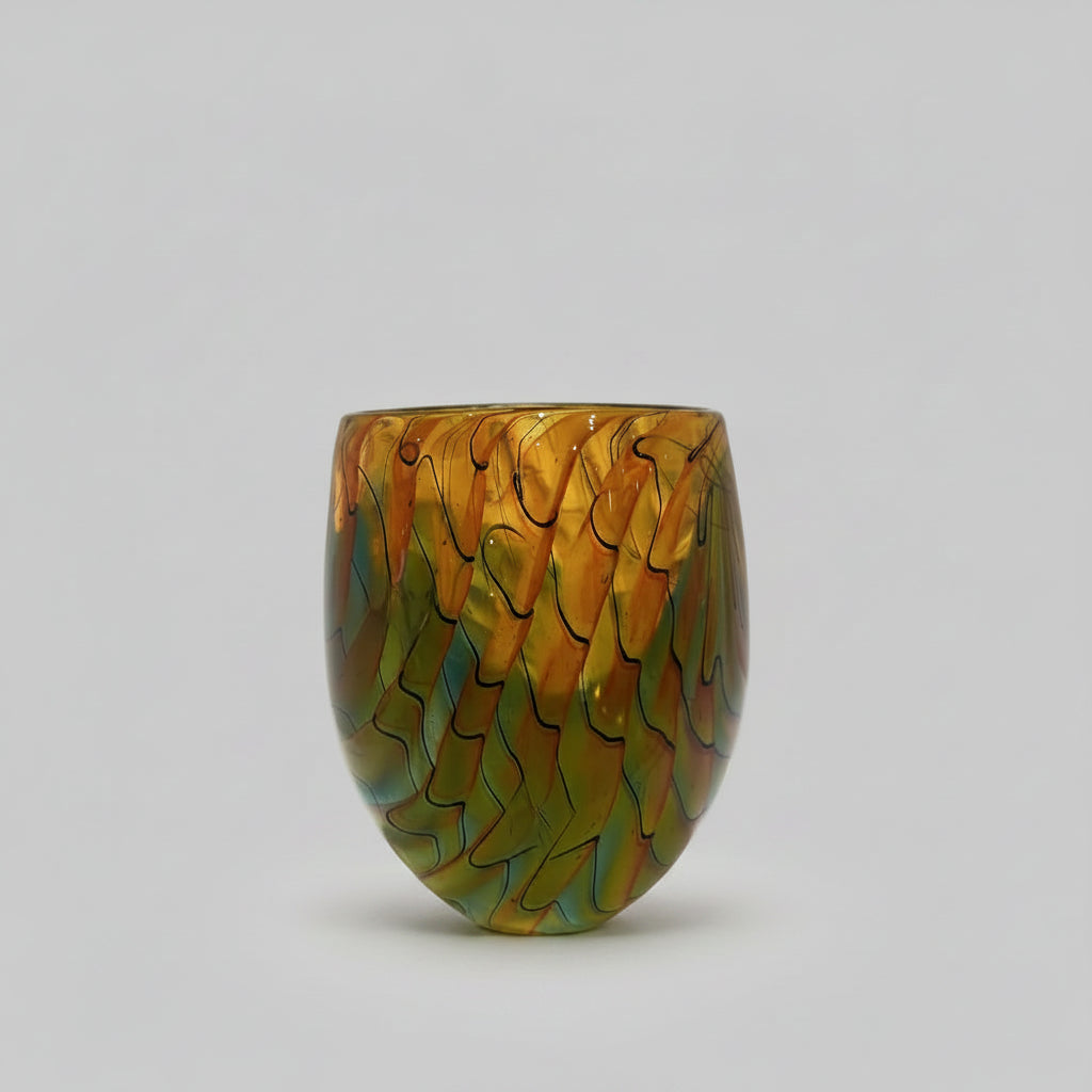 Peter Layton's Glass vase with colourful wavy pattern on a white surface