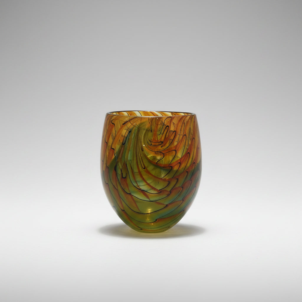 Colorful glass vase on a white surface with a neutral background
