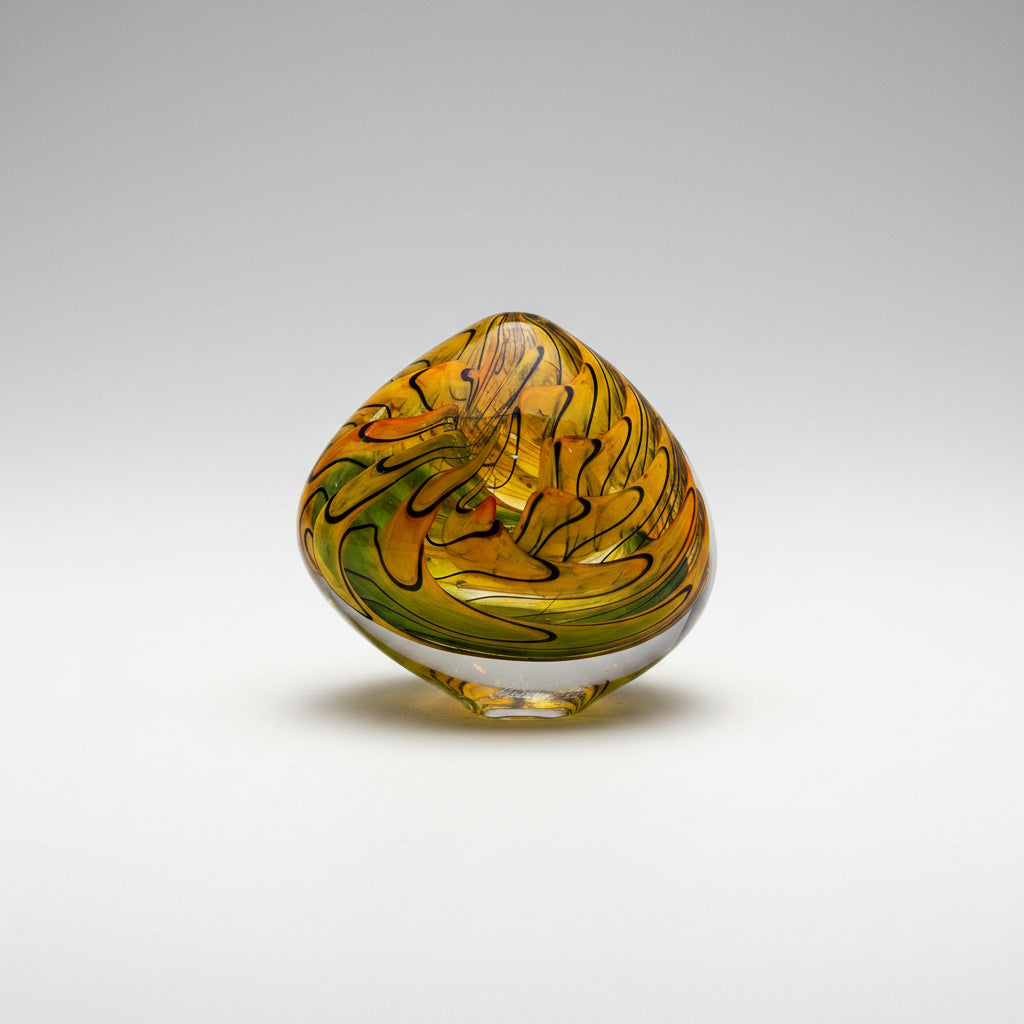 Decorative glass piece with yellow and green swirls on a white background