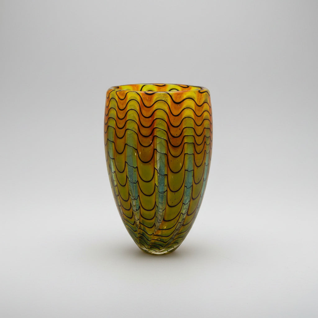 Peter Layton's Glass vase with wavy pattern on a white background