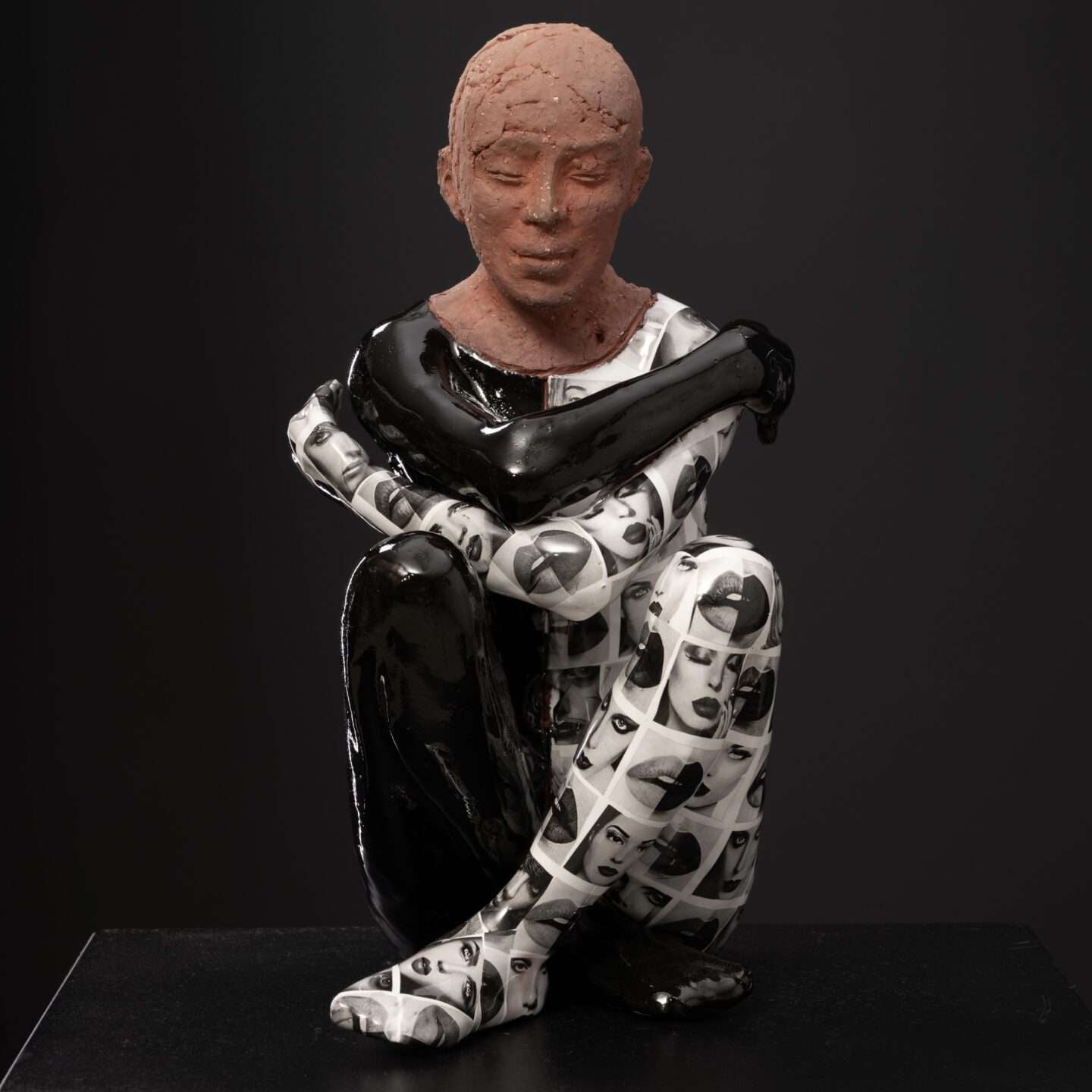 Ceramic sculpture of a person with a prosthetic leg on a black background
