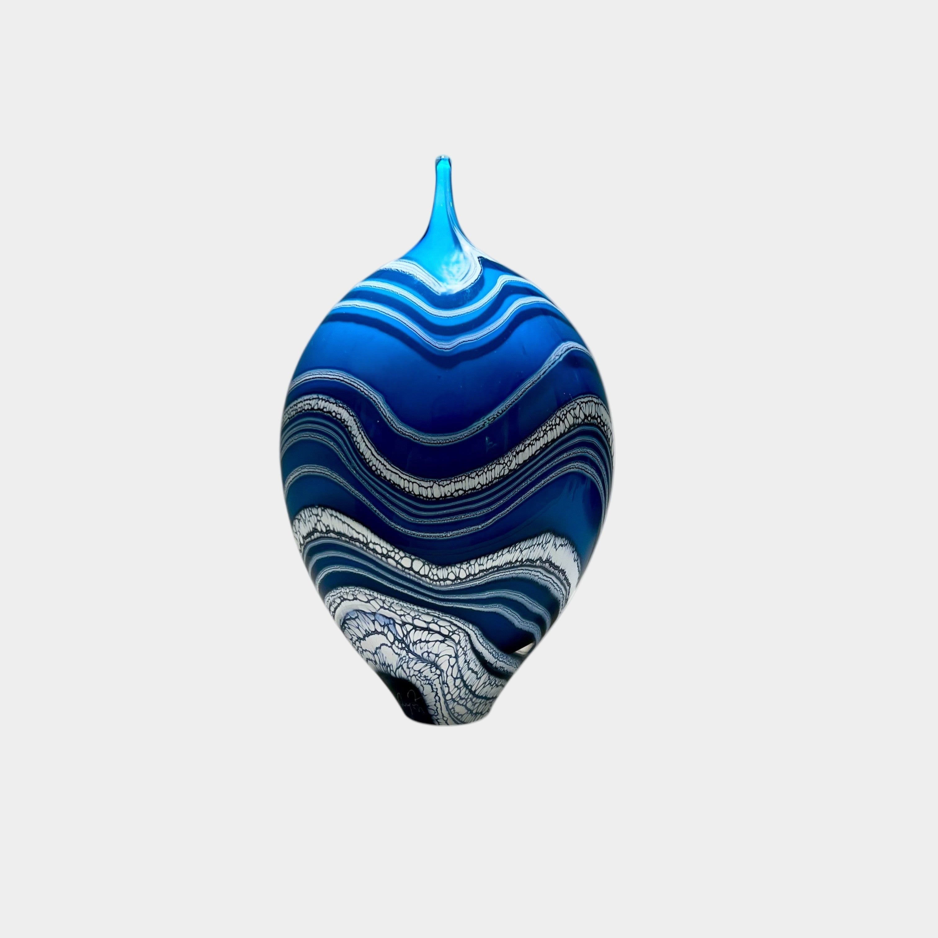 Blue and white decorative object with wavy patterns on a white background