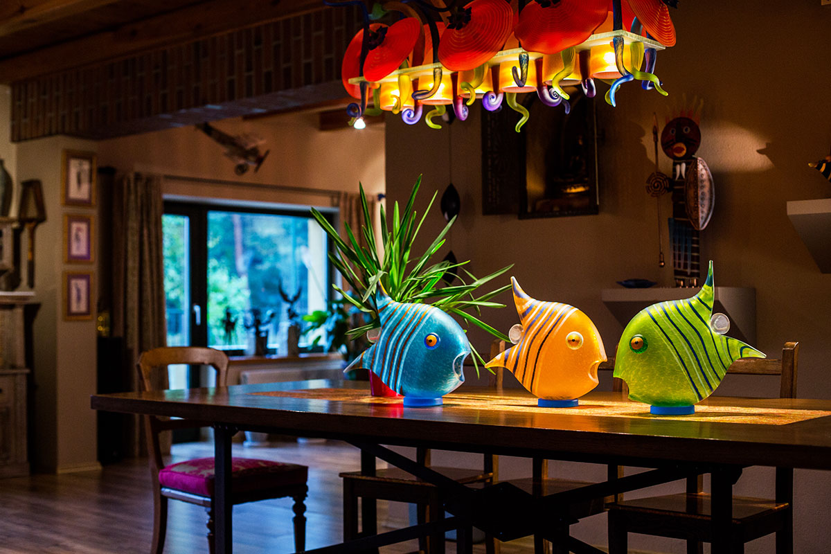 Colorful fish-shaped glass objects on a table with a blurred background