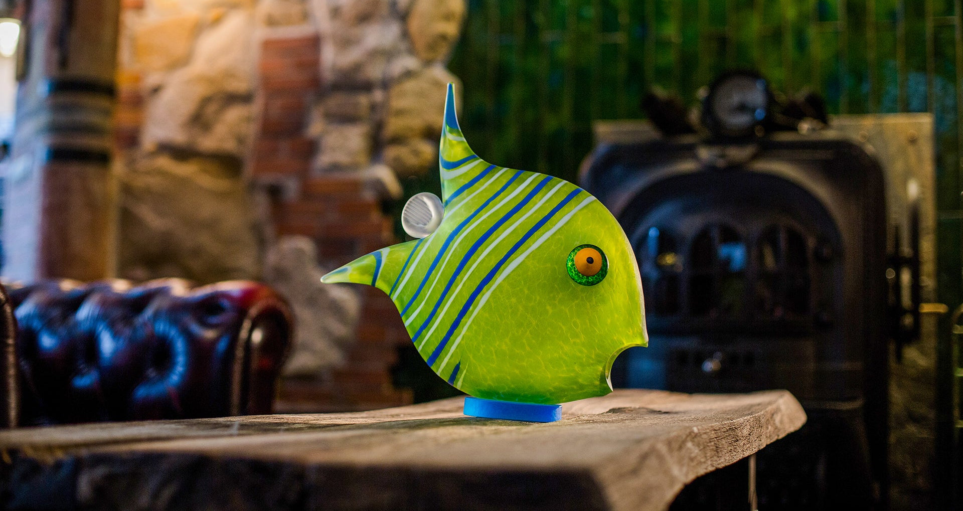 Decorative glass fish sculpture on a table with a blurred background